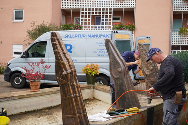 Kurz vor der Winterpause wurden der Cavalli-Brunnen im Gartacher Hof, der im Jahr 1994 von Künstlerin Ursula Stock geschaffen wurde, gereinigt und neu patiniert. Im Foto sehr gut zu erkennen sind die einzelnen Arbeitsschritte, die vor Ort von der Firma Skulptur Manufaktur Rohr GmbH aus Niefern-Öschelbronn erledigt wurden. Der vordere Pferdekopf ist komplett fertig, der mittlere wird vom Seniorchef gesäubert, der hinterste wird vom Juniorchef vorbereitet. Über die Wintermonate sprudelt der Brunnen witterungsbedingt nicht, aber im nächsten Frühjahr können sich die Bewohner des Gartacher Hofes und ihre Besucher wieder über den schönen Pferde-Brunnen freuen. 