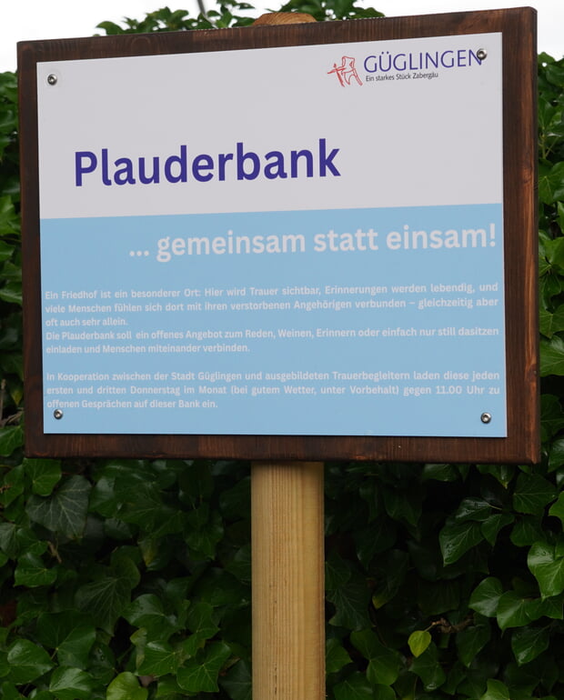 Ein Schild weist auf die Plauderbank hin.